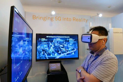 嘉賓在峰會現場利用VR設備觀看5G測試外場。